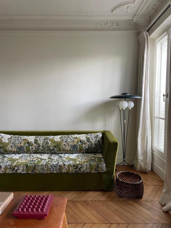 un canapé vert dans un salon avec une table dans l'établissement L'Atelier 35 with view of Montmartre, à Paris