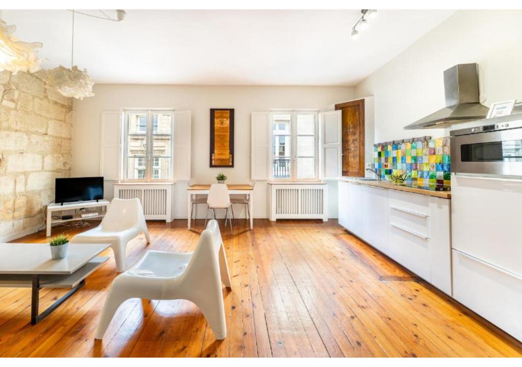 Il comprend un salon avec un mobilier blanc et une cuisine. dans l'établissement Appartement en Hypercentre - Le Teulère, à Bordeaux