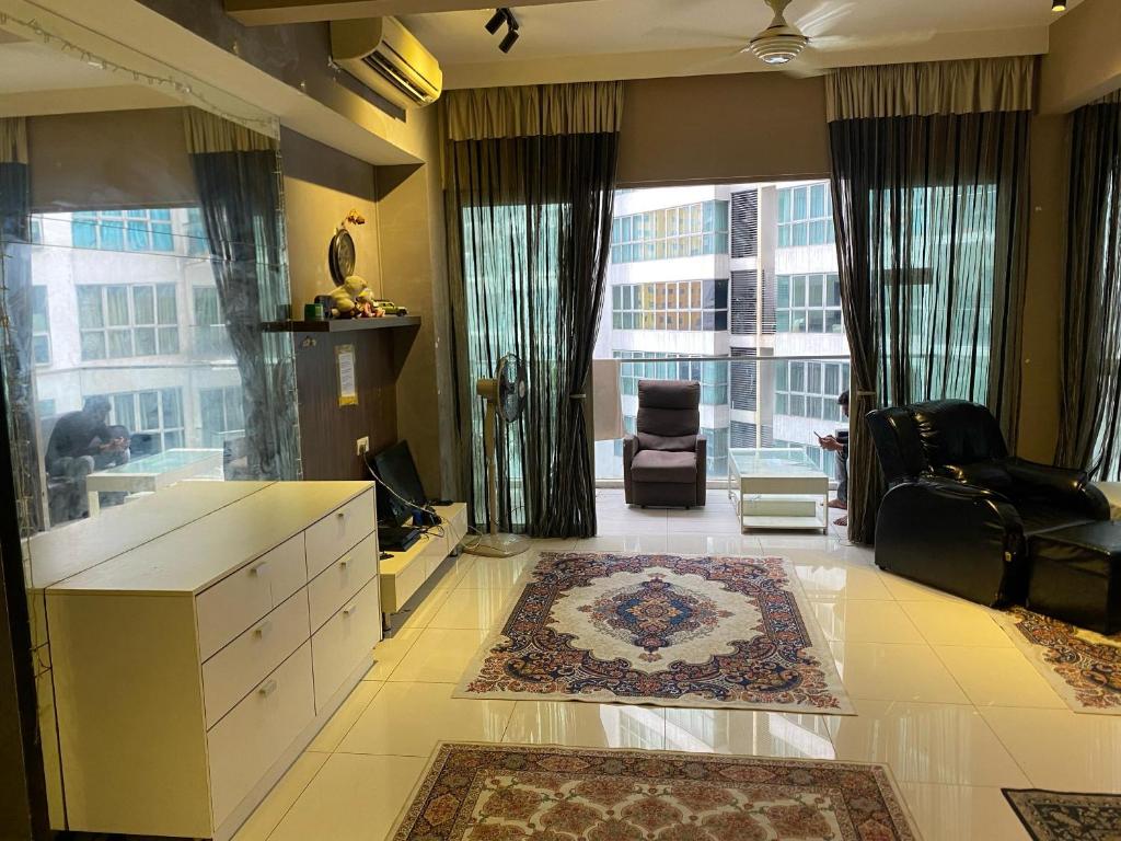 Una sala de estar con una gran ventana y un sofá y una silla. en Celestial Heights Hostel featuring Infinity Skypool, en Kuala Lumpur