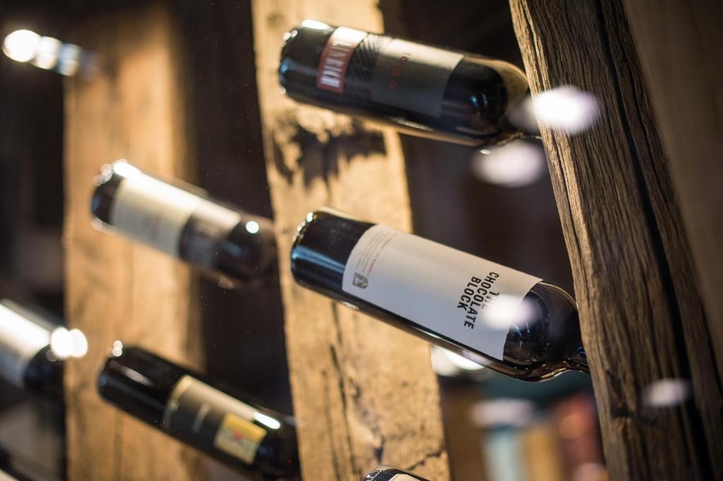 a group of wine bottles on a wooden door at Hotel Der Löwe LEBE FREI in Leogang