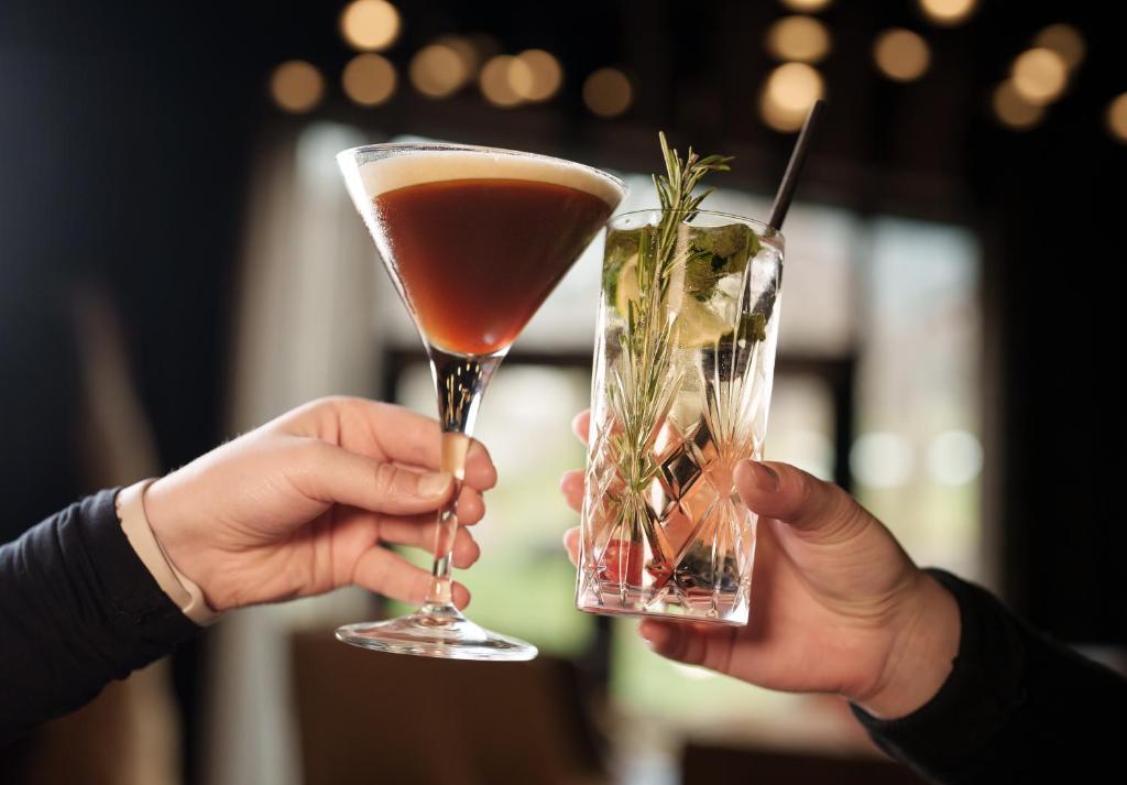 two people holding a drink in their hands at Hotel Der Löwe LEBE FREI in Leogang