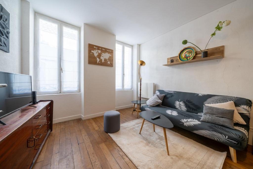 un salon avec un canapé et une télévision dans l'établissement Cocon Poyol Studio Bois, Wifi en Hyper Centre, à Montélimar