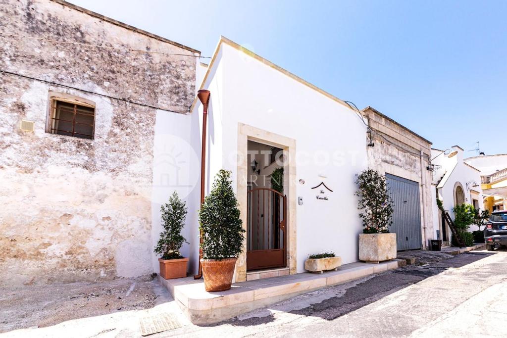 una casa sul lato di un edificio con piante in vaso di Na Chicca - B&B a Melendugno