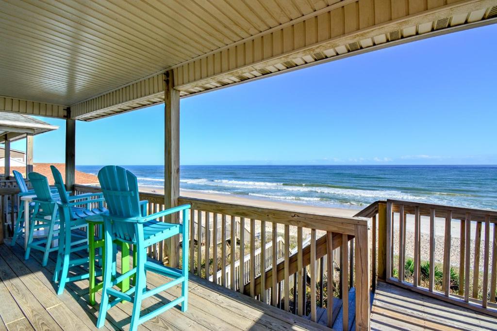 een veranda met blauwe stoelen en het strand bij Oakley's Oasis in Surf City