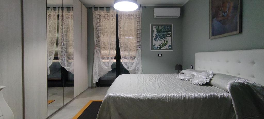 a bedroom with a bed in a room with windows at Guest House Confienza in Confienza