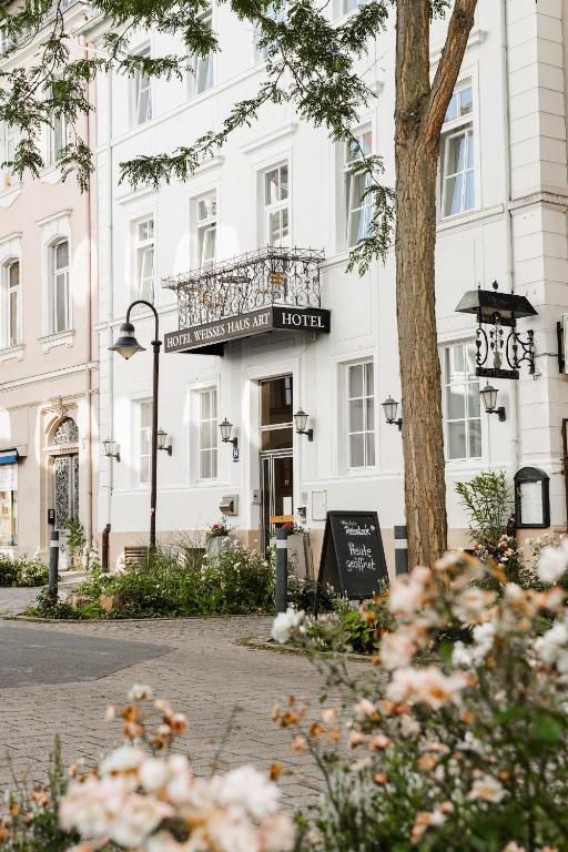 a white building with a balcony in front of it at Boutique-Hotel Weisses Haus Art in Bad Kissingen
