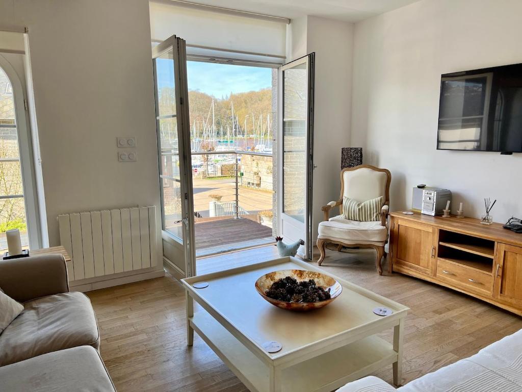 un salon avec un canapé et une table dans l'établissement La Maison Rose at Lyvet Port is a beautiful Pet Friendly Riverside Gite close to Dinan Sleeps 6, à La Vicomté-sur-Rance