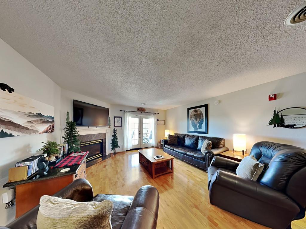 a living room with leather furniture and a fireplace at Top O the Pines Whispering Pines 253 in Pigeon Forge