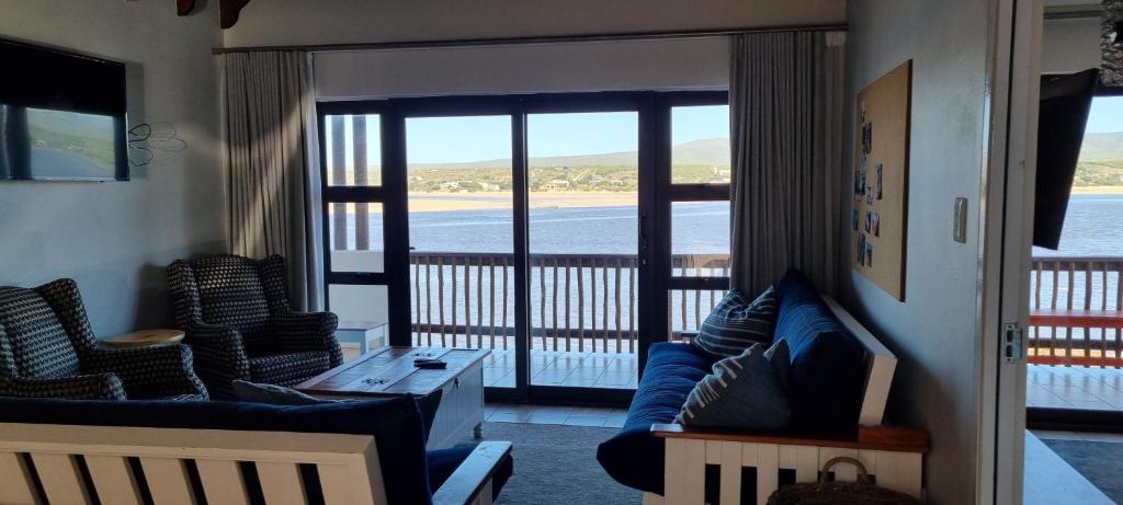a living room with a couch and chairs and a balcony at 109 at Breede in Witsand