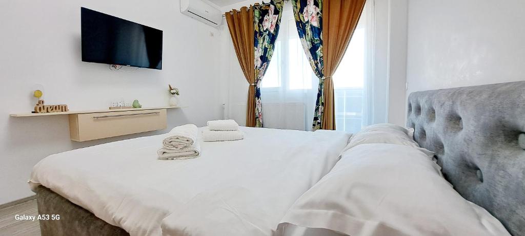 a bedroom with a bed with towels on it at Relax Home apartments in Iaşi