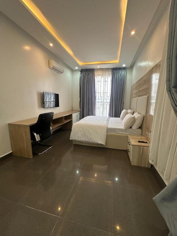 una camera da letto con un letto, una scrivania e un computer di Gladion Apartments a Dushekoro