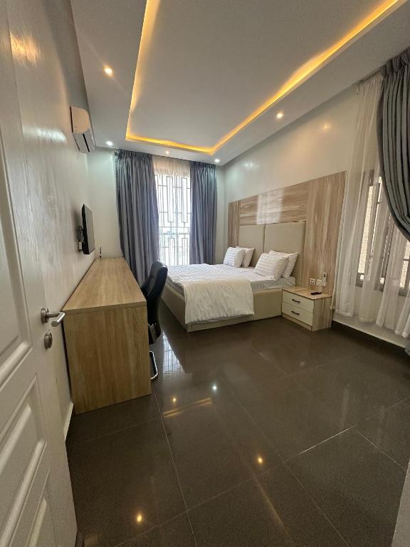 una camera d'albergo con letto e scrivania di Gladion Apartments a Dushekoro