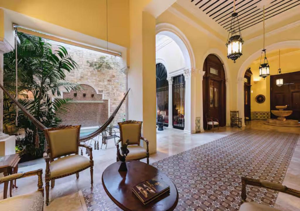 a lobby with chairs and a table in a building at La Casa del Centro, Mérida in Mérida