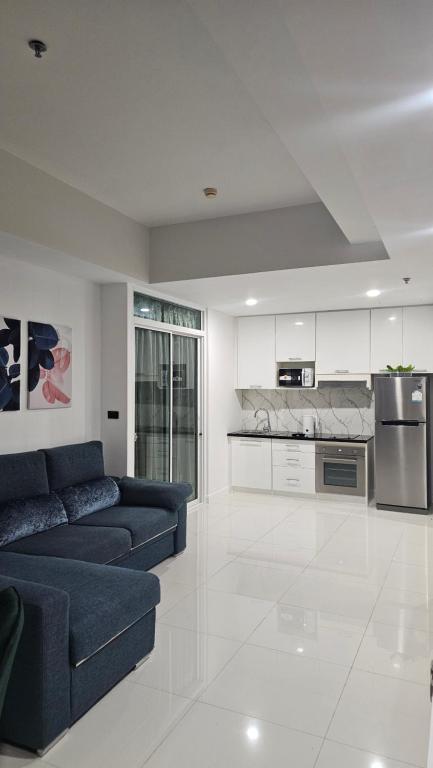 a living room with a blue couch and a kitchen at Patong Tower Apartment Family Room See View in Patong Beach