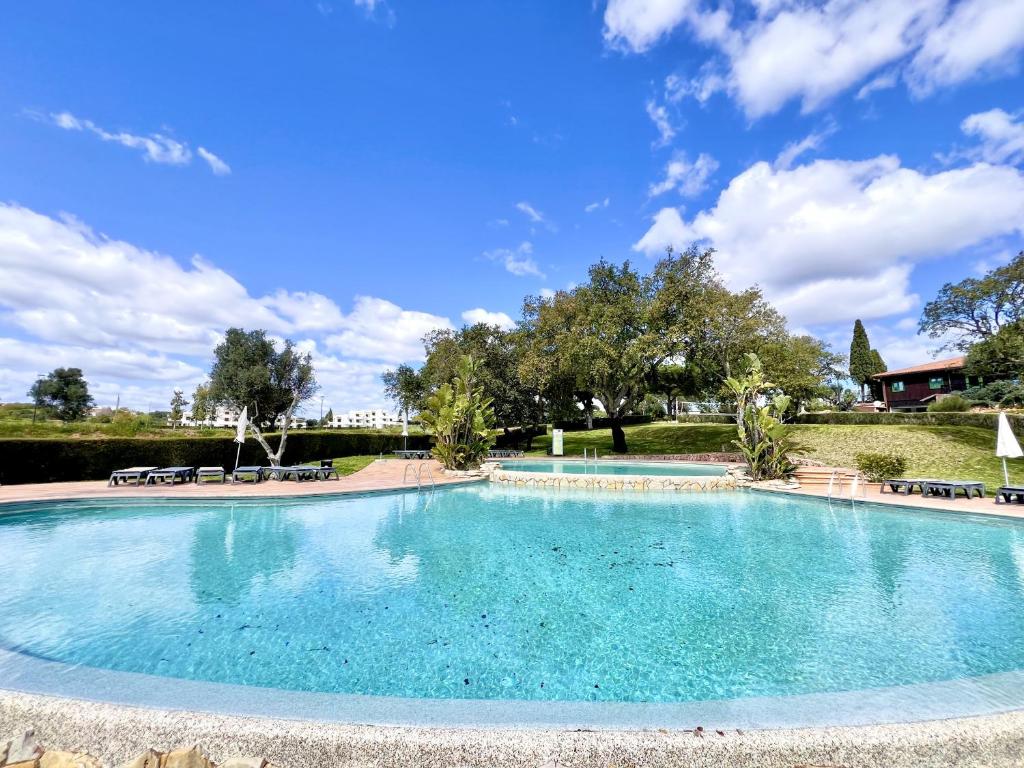 a large swimming pool with blue water in a park at Albufeira Balaia Golf Vilage 7 With Pool by Homing in Albufeira