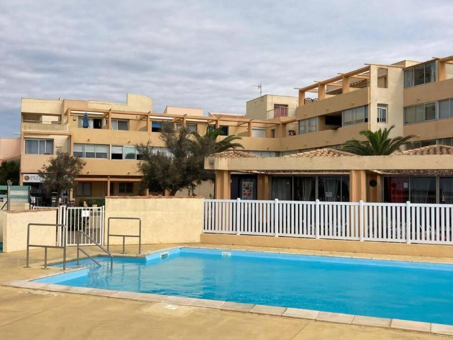 une grande piscine bleue devant un immeuble dans l'établissement Charmant duplex, à Leucate-Plage