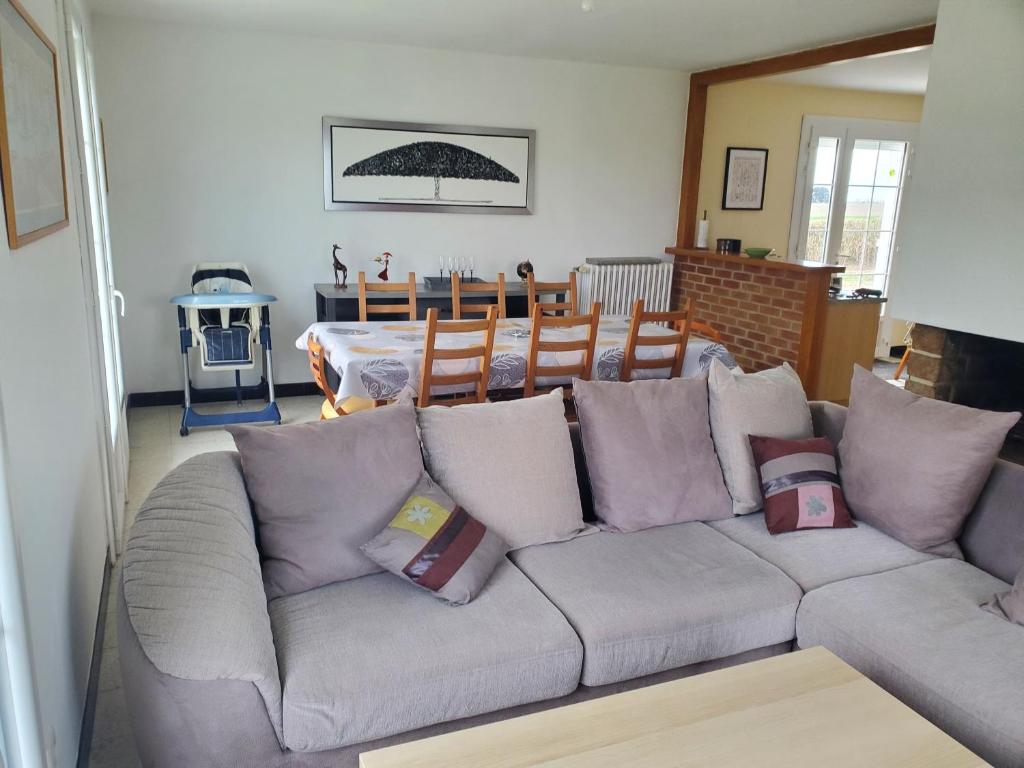 a living room with a gray couch with pillows at A l'horizon du Mont in Pontorson