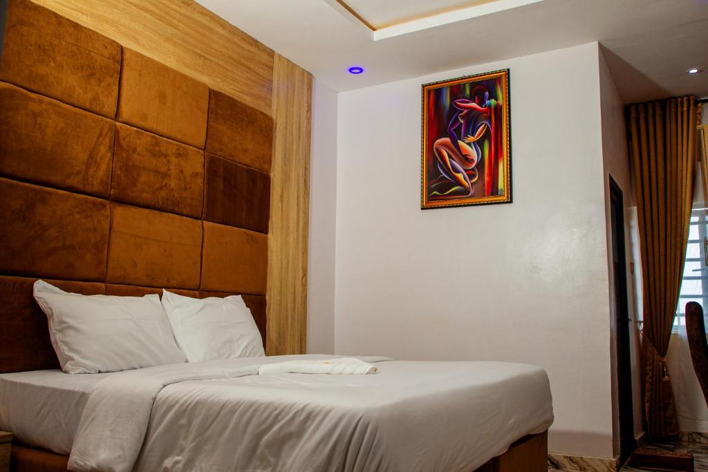 MeranにあるDel Migos Hotel & Suitesのベッドと壁に絵が飾られた寝室