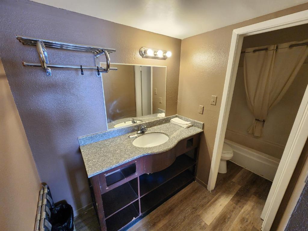 a bathroom with a sink and a mirror at Satellite Inn in Alamogordo