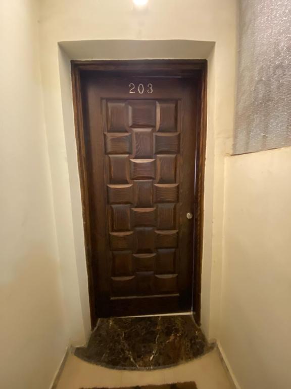 Una puerta marrón en una habitación con suelo de mármol en مكانك - MakanK, en Seis de Octubre