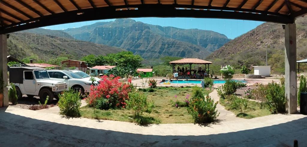 a white truck parked in a yard with mountains in the background at Finca la playita in Jordán