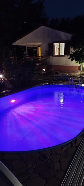 a swimming pool with purple lights on top of it at Levendulás Ház Balatonakarattya in Balatonkenese