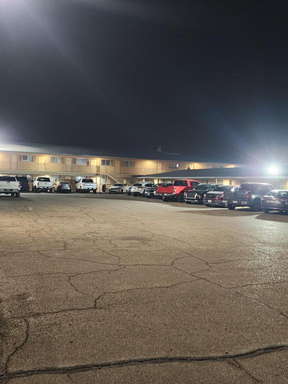 a parking lot with cars parked in front of a building at Satellite Inn in Alamogordo