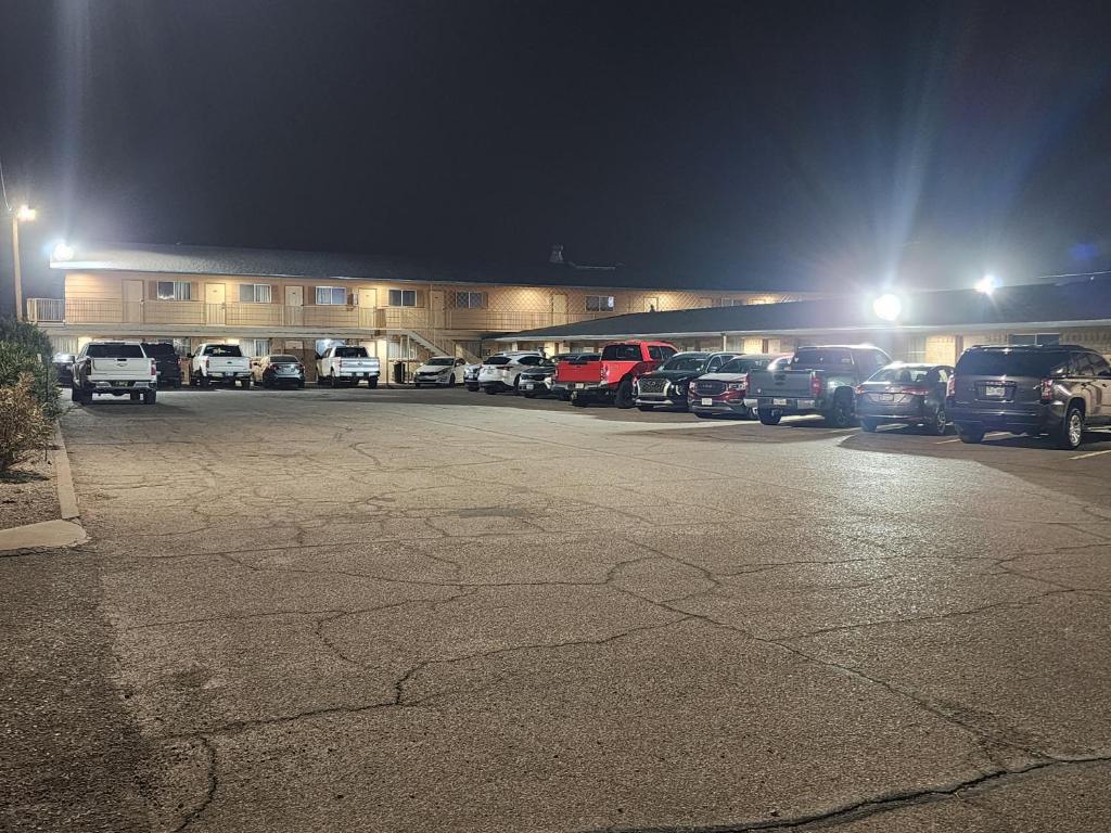 a parking lot with cars parked in front of a building at Satellite Inn in Alamogordo