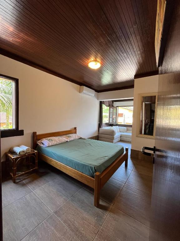 a bedroom with a bed with a wooden ceiling at Canto das Toninhas Guest House in Ubatuba