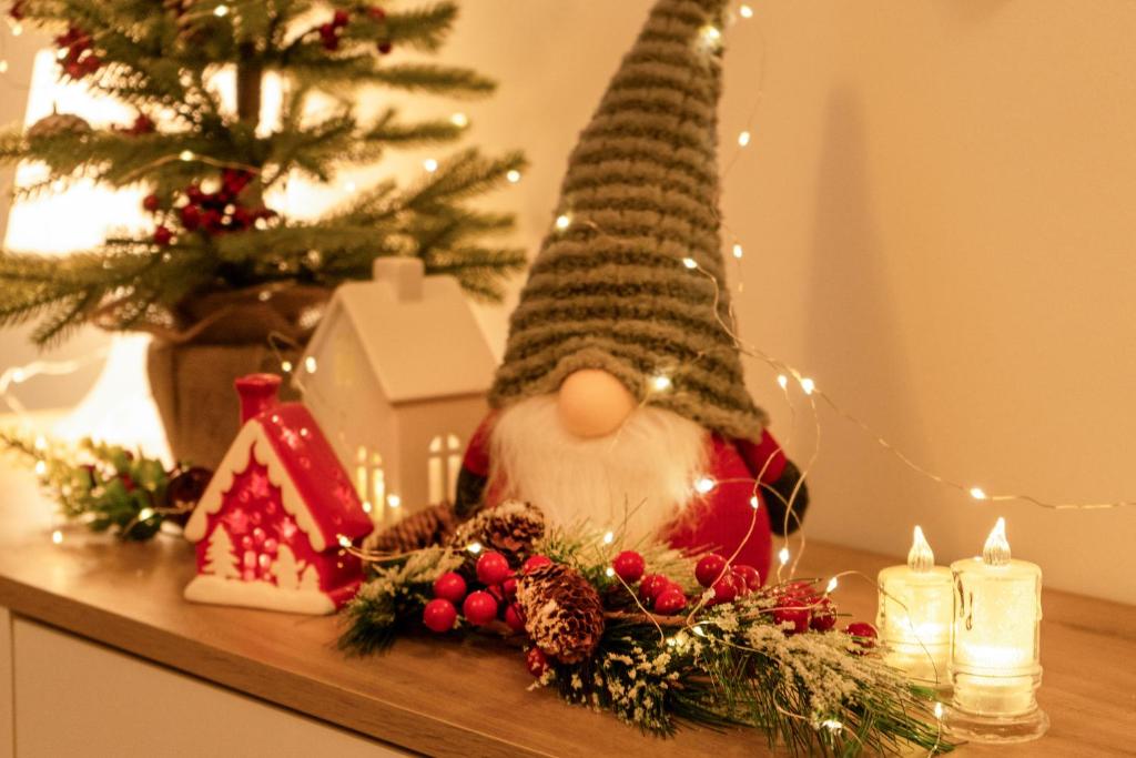 Eine Santa Claus Puppe auf einem Tisch neben einem Weihnachtsbaum in der Unterkunft Spacious Studio Close to City Center l Washing Machine l Kitchen in Novi Sad