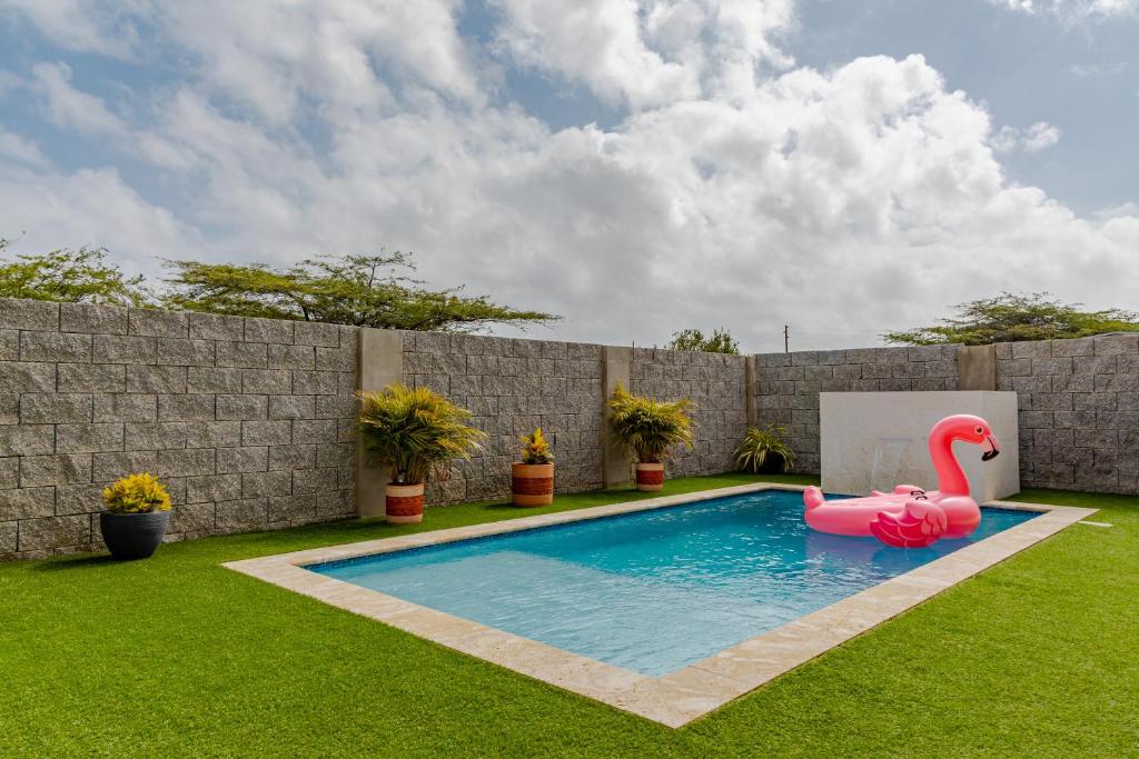 a pool with a pink inflatable flamingo in a yard at SPECIAL OFFER !! 7 min to Beach - Newly-Renovated Modern Luxury Home in Paradera