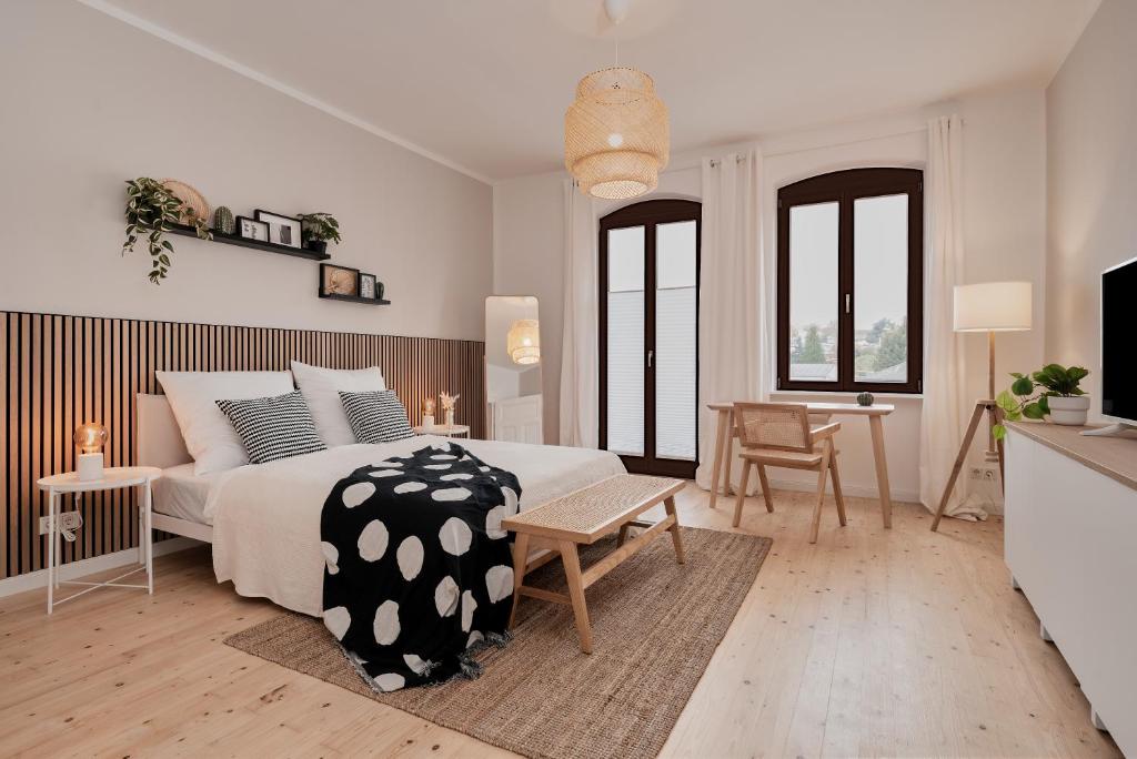 Jugendstil-Altbauwohnung an der Karlsaue - 120qm, Klimaanlage, neu saniert, zentrale Lage في كاسيل: غرفة نوم بيضاء مع سرير كبير وطاولة