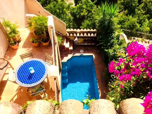 einen Blick über einen Pool mit Blumen in der Unterkunft Casa Azahar in Saleres