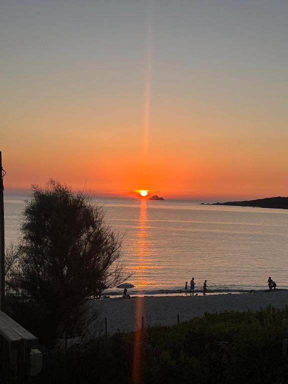 - des personnes marchant sur la plage au coucher du soleil dans l'établissement Loretto proche centre ville et plage, à Ajaccio
