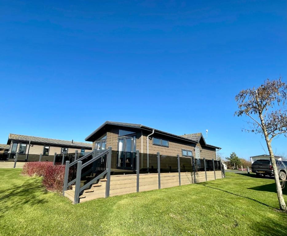 a house with a large deck on a lawn at Oakwood Lodge in Cheswick