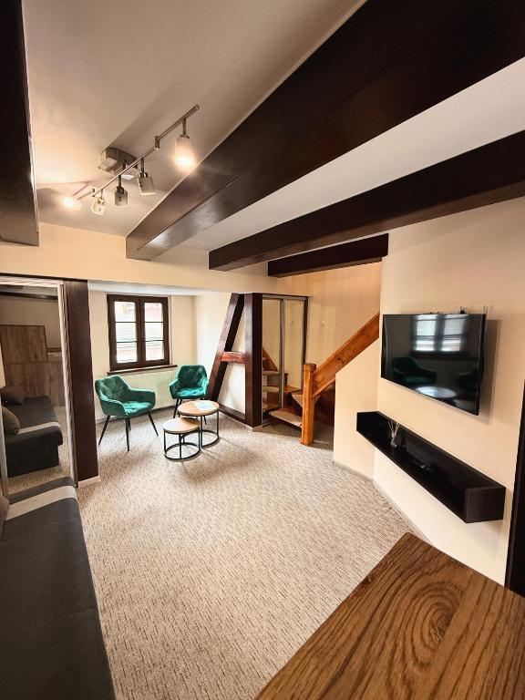 a living room with a flat screen tv and a couch at Apartamenty WW in Toruń