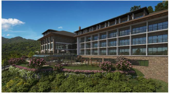 a large building with flowers in front of it at Gran Paradiso Resort - Campos do Jordão in Campos do Jordão