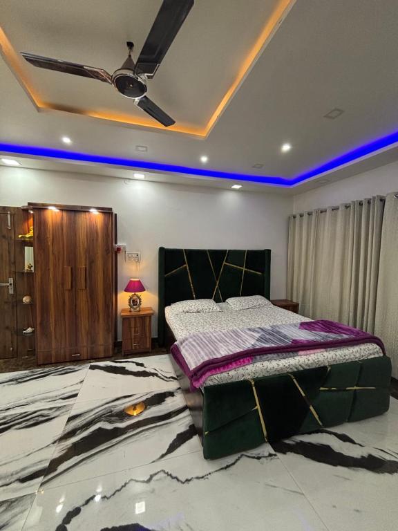 a bedroom with a large bed and a ceiling at Gupta Residence. in Dhanbād