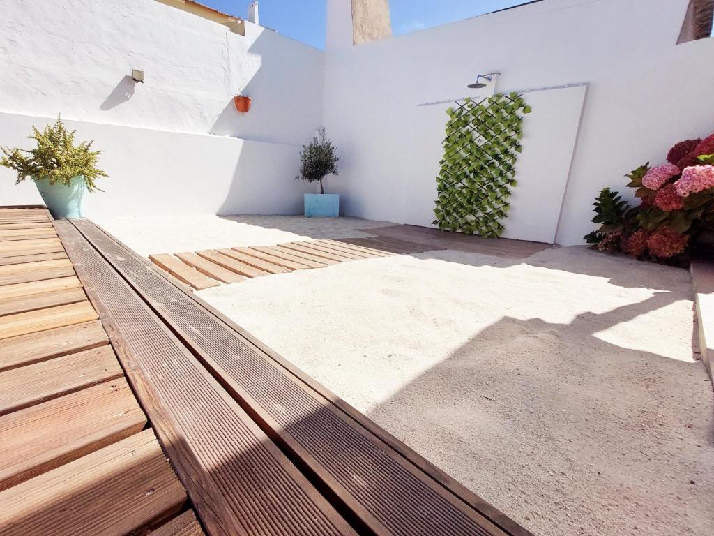 a porch with a wooden bench and plants at A Casa dos Azulejos in Santiago do Cacém