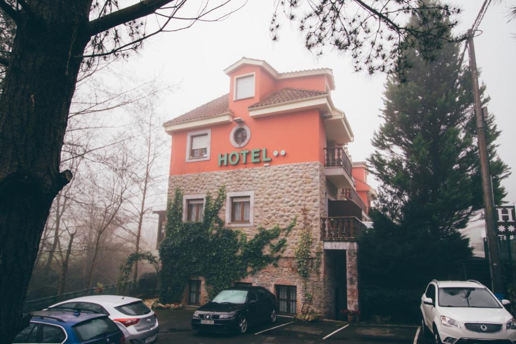 un hôtel avec des voitures garées devant lui dans l'établissement Hotel Rural El Molino, à Soto de Cangas