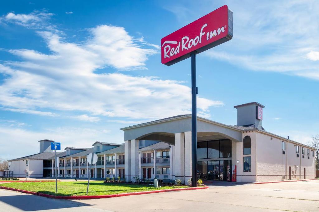 a building with a red sign in front of it at Red Roof Inn Stafford, TX in Stafford