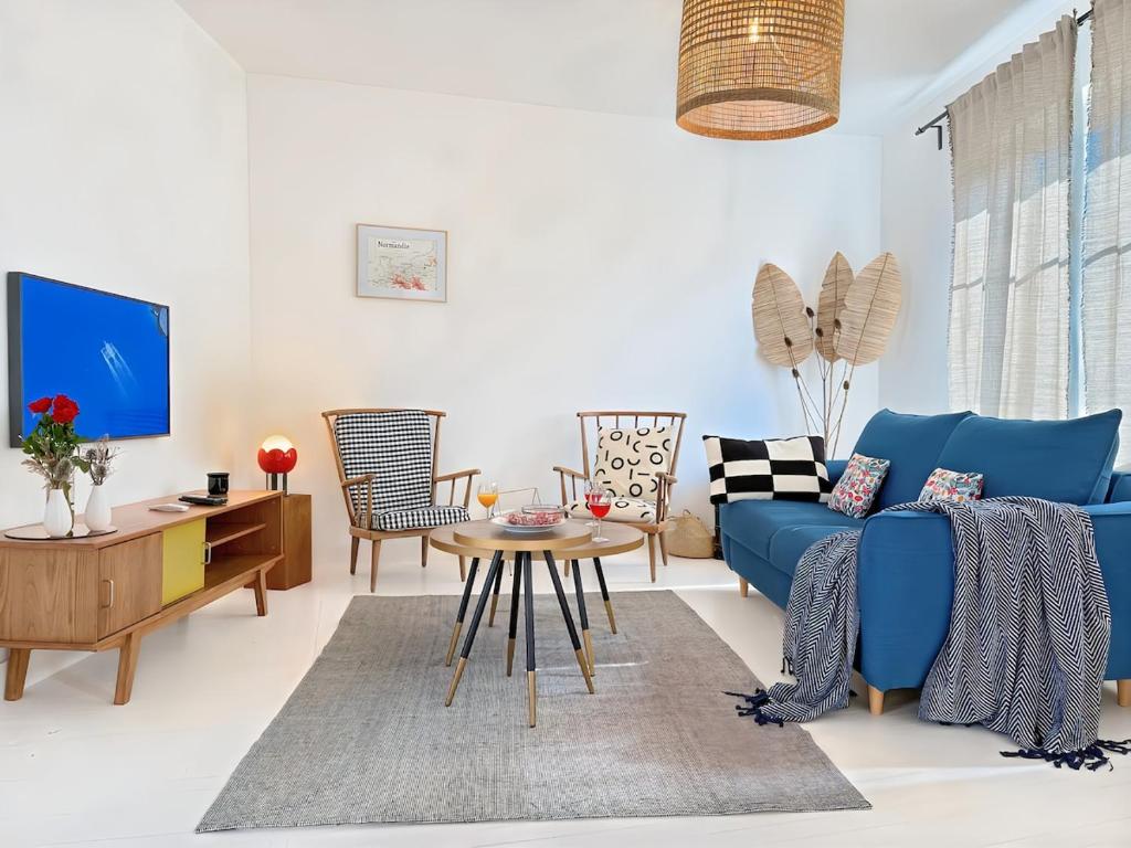 un salon avec un canapé bleu et une table dans l'établissement HérouVillers - Bright duplex in Hypercentre & Beach a stone's throw away, à Villers-sur-Mer