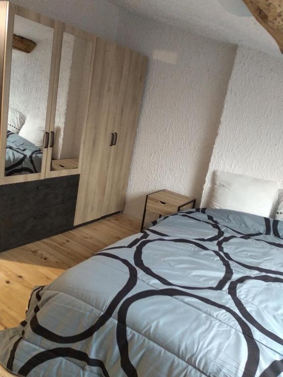 une chambre avec un grand lit et un miroir dans l'établissement Chez Amandine, à Molières