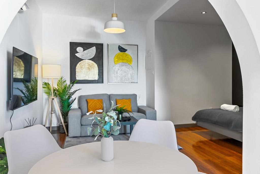 a living room with a couch and a table and chairs at Orange Tree Studio, just steps from the sea in Paphos City