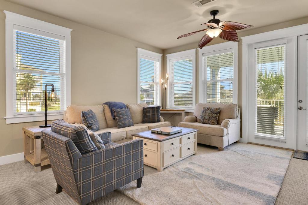 a living room with a couch and chairs and windows at Mannanan Mac Lir in Galveston
