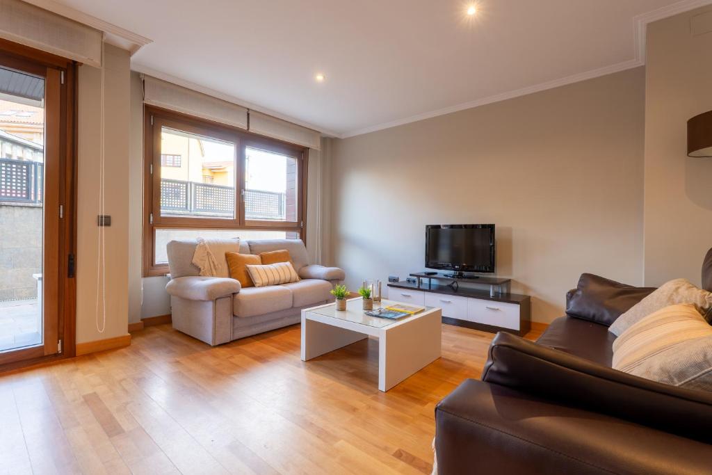 a living room with a couch and a tv at Miracielos in Barro de Llanes