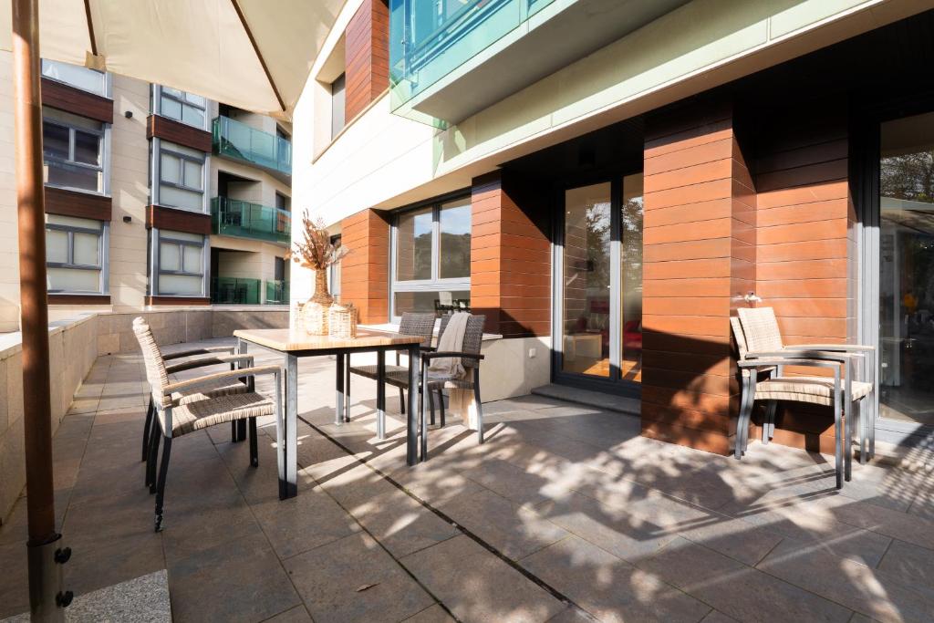 a patio with a table and chairs and a building at Miracielos in Barro de Llanes