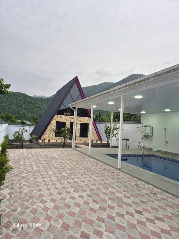 ein Haus mit Swimmingpool neben einem Haus in der Unterkunft BUTAWAY Homes in Qəbələ