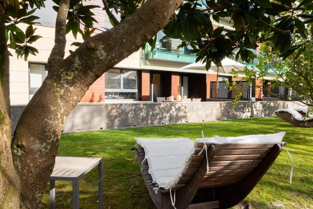 a white couch sitting under a tree next to a chair at Miracielos in Barro de Llanes