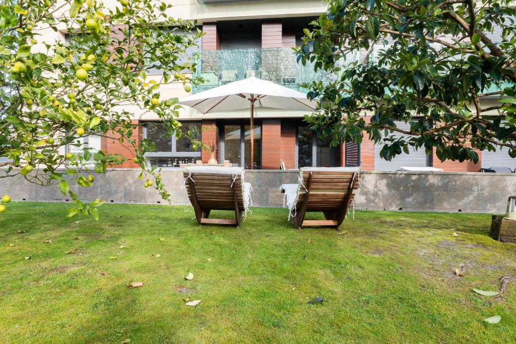 two chairs and a table with an umbrella in a yard at Miracielos in Barro de Llanes